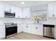 Updated kitchen boasts stainless steel appliances and white cabinetry with black hardware at 1579 Brady Dr, Deltona, FL 32725