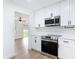 Clean kitchen with white cabinets, stainless appliances, and a view into a living area at 1579 Brady Dr, Deltona, FL 32725