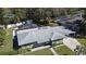 Aerial view of a well-maintained home featuring a gray roof, green siding, and a neatly landscaped yard at 1590 N Page Dr, Deltona, FL 32725