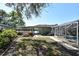 View of backyard featuring a lush lawn, garden, and a partially screened-in pool at 1590 N Page Dr, Deltona, FL 32725