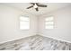 Bright room showcasing wood-look flooring, ceiling fan, with natural light coming through the windows at 1590 N Page Dr, Deltona, FL 32725