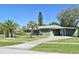 Charming single-story home with green paint, lovely shutters, carport, manicured lawn, and tropical landscaping at 1590 N Page Dr, Deltona, FL 32725
