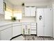 Bright kitchen features white cabinetry, a refrigerator with an ice maker, and a window with a view at 1590 N Page Dr, Deltona, FL 32725