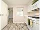 Open-concept kitchen featuring an oven with a sunflower-themed towel and wood-look flooring at 1590 N Page Dr, Deltona, FL 32725