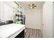 A functional laundry area with washer, dryer, water heater, storage shelving, and wood-look flooring at 1590 N Page Dr, Deltona, FL 32725