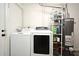 Laundry room with washer, dryer, water heater, storage racks and a door to an adjacent space at 1590 N Page Dr, Deltona, FL 32725