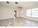 Light and airy living room with wood-look flooring, ceiling fan, and abundant natural light at 1590 N Page Dr, Deltona, FL 32725
