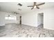 Spacious living room showcases a ceiling fan, wood-look floors, and open access to the kitchen at 1590 N Page Dr, Deltona, FL 32725