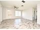 Bright living room with wood-look flooring, a ceiling fan, and a light-colored front door at 1590 N Page Dr, Deltona, FL 32725