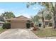Charming single-story home featuring stone accents, a two-car garage, and mature landscaping at 1651 Kenlyn Dr, Longwood, FL 32779