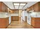 Bright kitchen featuring wood cabinets, white appliances, and a skylight at 1651 Kenlyn Dr, Longwood, FL 32779