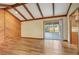 Light-filled living room featuring a wood-paneled wall, exposed beams, and sliding glass doors at 1651 Kenlyn Dr, Longwood, FL 32779