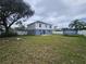 Large backyard boasts green lawn, privacy fence, and mature tree at 2235 Rabenton Rd, Deltona, FL 32738