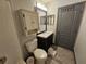 Bathroom featuring vanity sink, mirror, toilet, white tub, white tile, and dark hardware at 2235 Rabenton Rd, Deltona, FL 32738