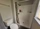 Bathroom features a white shower with curtain, toilet, towel rack, and small window at 2235 Rabenton Rd, Deltona, FL 32738