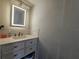 Bathroom vanity featuring a sink, drawers, and a decorative lighted mirror at 2235 Rabenton Rd, Deltona, FL 32738