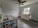 Bright Bedroom featuring a crib, changing table on a dresser, vinyl floors, and ceiling fan at 2235 Rabenton Rd, Deltona, FL 32738