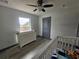 Bedroom featuring a crib, changing table on a dresser, vinyl floors, doors, and ceiling fan at 2235 Rabenton Rd, Deltona, FL 32738