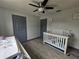 Bedroom featuring a crib, changing table on a dresser, vinyl floors, doors, and ceiling fan at 2235 Rabenton Rd, Deltona, FL 32738
