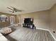 Living room featuring gray wood-look flooring, a ceiling fan, and neutral walls at 2235 Rabenton Rd, Deltona, FL 32738