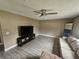 Living room featuring gray wood-look flooring, a ceiling fan, neutral walls and a beige couch at 2235 Rabenton Rd, Deltona, FL 32738