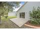 A concrete patio is located on the back of the home, bordered by landscaping at 232 Gala Cir, Daytona Beach, FL 32124