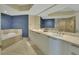 This bathroom features a dual sink vanity with a large mirror, a shower, and a soaking tub at 241 Riverside Dr # 1502, Daytona Beach, FL 32117