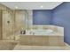 This bathroom features a glass shower, a soaking tub, and neutral tile throughout at 241 Riverside Dr # 1502, Daytona Beach, FL 32117