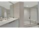 Bathroom featuring a marble vanity, framed mirror, and a glass-enclosed shower with a built-in bench at 241 Riverside Dr # 1502, Daytona Beach, FL 32117