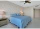 Comfortable bedroom featuring a ceiling fan, neutral walls, and light-colored tiled flooring at 241 Riverside Dr # 1502, Daytona Beach, FL 32117