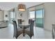 Bright dining area featuring a glass table, four woven chairs, and stunning water views through large windows at 241 Riverside Dr # 1502, Daytona Beach, FL 32117