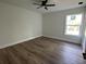 Bright bedroom features wood floors, a ceiling fan and natural light from a window at 283 Wildwood Dr, New Smyrna Beach, FL 32168