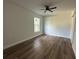 Bright bedroom featuring wood-look floors, a modern ceiling fan, and natural light from a window at 283 Wildwood Dr, New Smyrna Beach, FL 32168