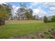 Large grassy backyard with a wooded area and partial view of a neighboring home at 291 Northcote Ct, Deland, FL 32724