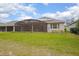 A spacious backyard featuring a screened lanai, lush green lawn, and mature landscaping at 291 Northcote Ct, Deland, FL 32724