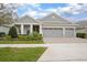 Charming single-story home featuring a three-car garage, manicured landscaping, and a welcoming front porch at 291 Northcote Ct, Deland, FL 32724