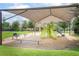 Community playground featuring slides and play equipment under a shade canopy, surrounded by green lawns at 291 Northcote Ct, Deland, FL 32724