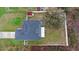 Aerial view of a house with solar panels, a fenced yard, and surrounding greenery showing the property's boundaries at 3318 Dewberry Dr, Deltona, FL 32738