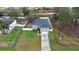 Aerial view of a home with solar panels, a long driveway, well-manicured lawn and a fenced yard at 3318 Dewberry Dr, Deltona, FL 32738