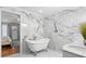 Elegant bathroom with a standalone tub, marble walls, and an open doorway to the main bedroom at 3318 Dewberry Dr, Deltona, FL 32738