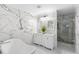 Bright bathroom with a standalone tub, double vanity, and a glass-enclosed shower with marble wall at 3318 Dewberry Dr, Deltona, FL 32738