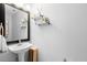 Modern bathroom featuring a pedestal sink, stylish mirror, and floating shelves at 3318 Dewberry Dr, Deltona, FL 32738