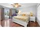 Bright bedroom with wood floors, a white-framed bed with decorative pillows, and a relaxing recliner near the window at 3318 Dewberry Dr, Deltona, FL 32738