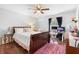 Bedroom featuring a wood-framed bed, ceiling fan, and a desk with computer, providing a cozy and functional space at 3318 Dewberry Dr, Deltona, FL 32738