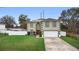 Two-story home with a well-manicured lawn, attached two-car garage, and neutral siding, offering great curb appeal at 3318 Dewberry Dr, Deltona, FL 32738
