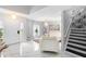 Elegant foyer featuring a staircase, a modern light fixture, and sleek marble floors leading to a bright living space at 3318 Dewberry Dr, Deltona, FL 32738