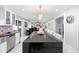 Open-concept kitchen featuring a black island, stainless steel appliances, and modern white cabinetry at 3318 Dewberry Dr, Deltona, FL 32738