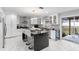 Modern kitchen with a large island, sleek white cabinets, stainless steel appliances and a sliding glass door at 3318 Dewberry Dr, Deltona, FL 32738