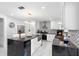 Bright kitchen featuring a black island, white cabinetry, stainless appliances, and modern backsplash at 3318 Dewberry Dr, Deltona, FL 32738