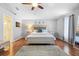 Bright main bedroom featuring a comfortable bed, hardwood floors, and neutral decor with ensuite bathroom access at 3318 Dewberry Dr, Deltona, FL 32738